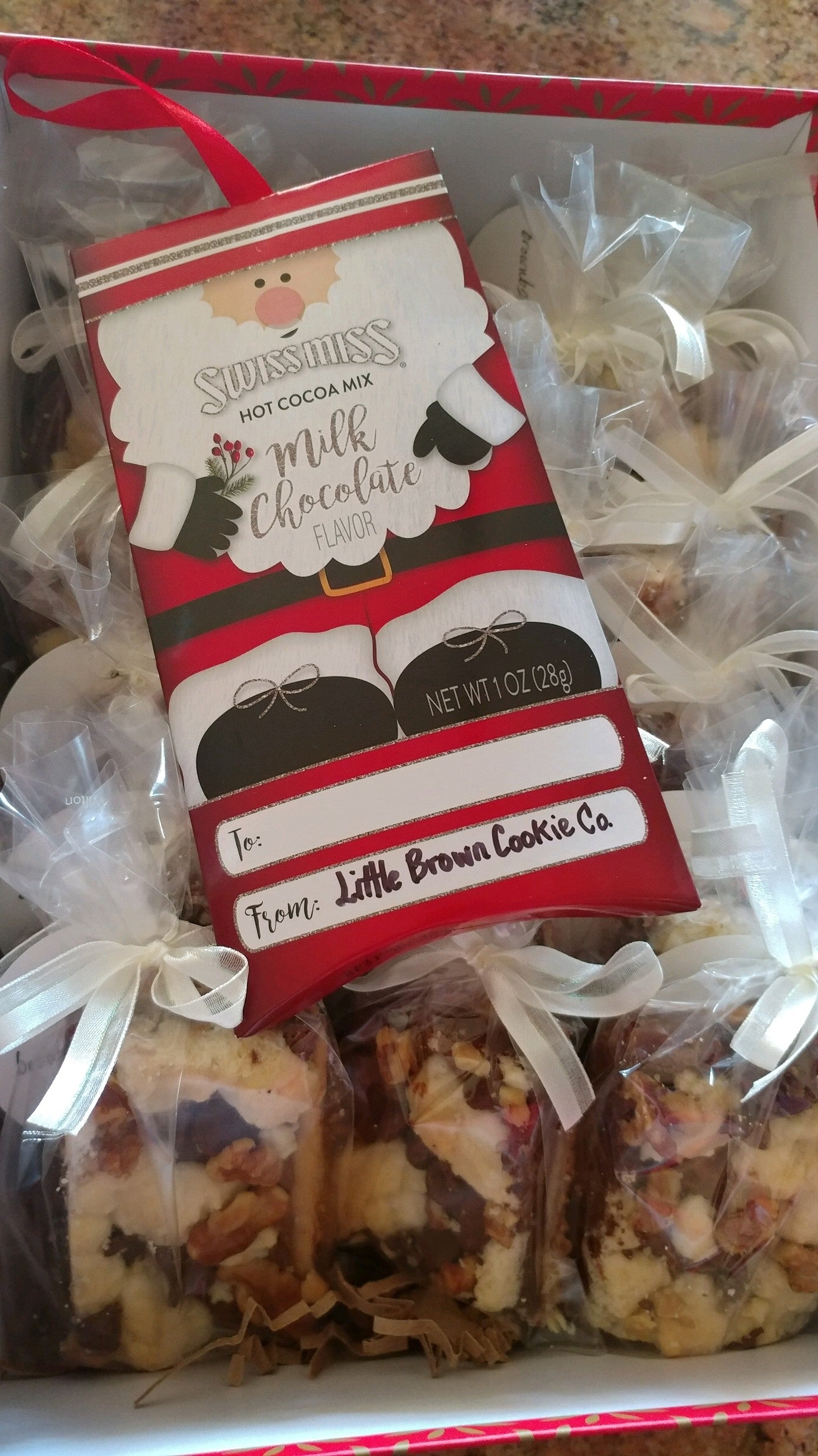 Chocolate crumb bars and a package of Swiss Miss Hot Chocolate mix in a ready to be shipped box